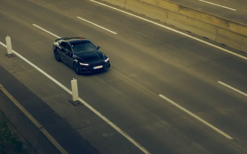 Black private hire car on a motorway showing taxi journey costs